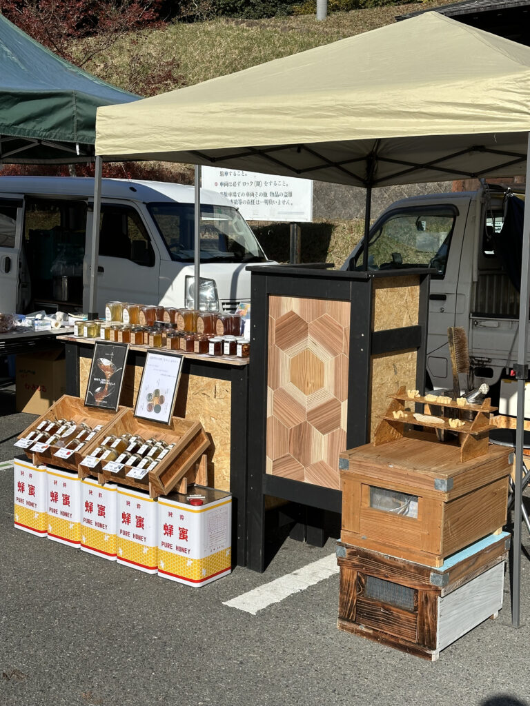 テントの下に木製什器を設置しはちみつを販売