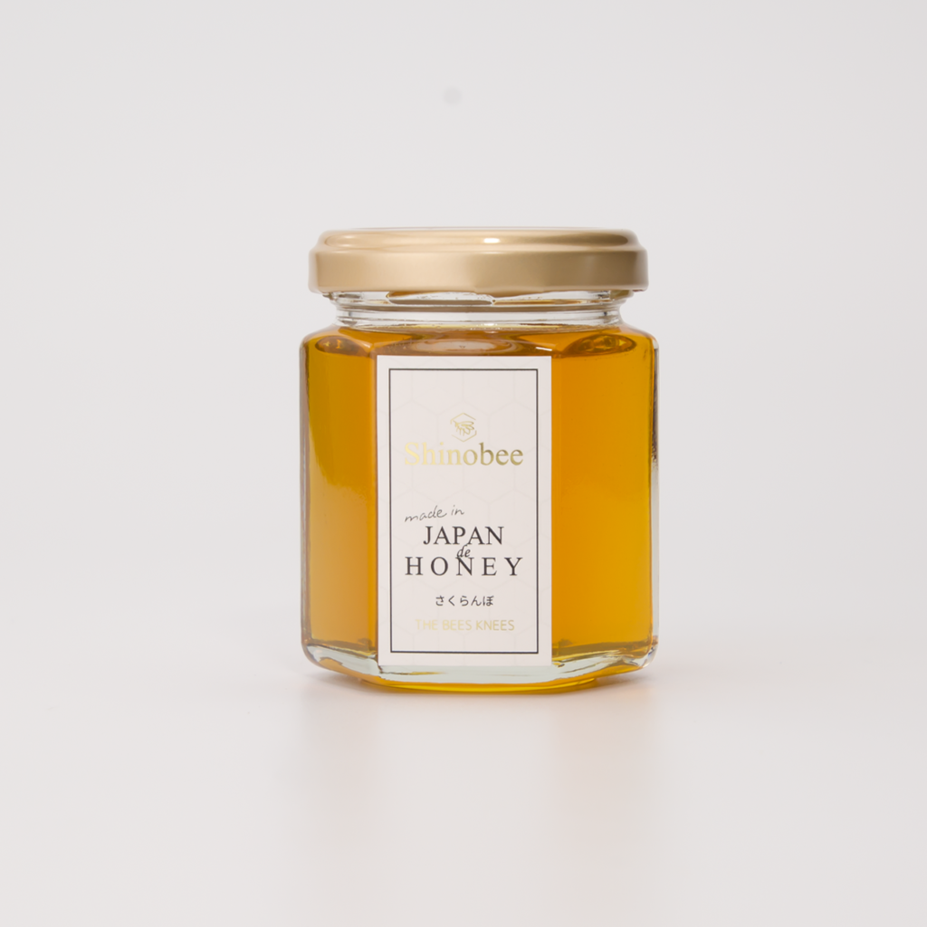 白い背景に瓶に入ったさくらんぼのはちみつ